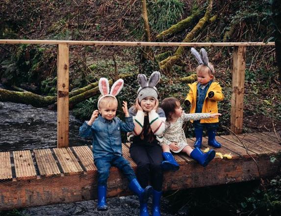 4 children sitting on a wall dressed in Easter costumes