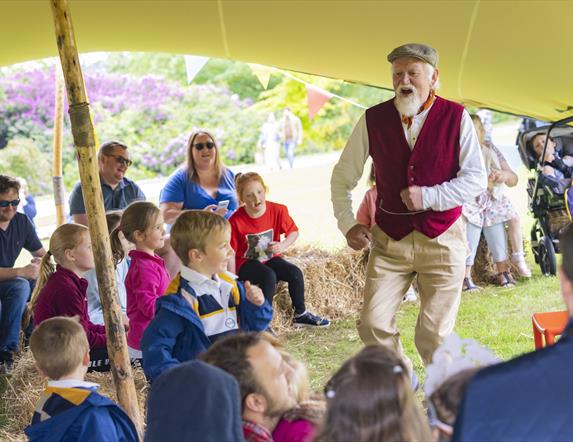 A storyteller is talking to children on the grounds of Hillsborough Castle and Gardens