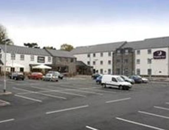 Image shows front of hotel and car parking spaces