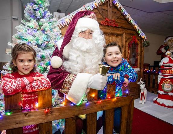 Image is of Santa Claus and children at his grotto