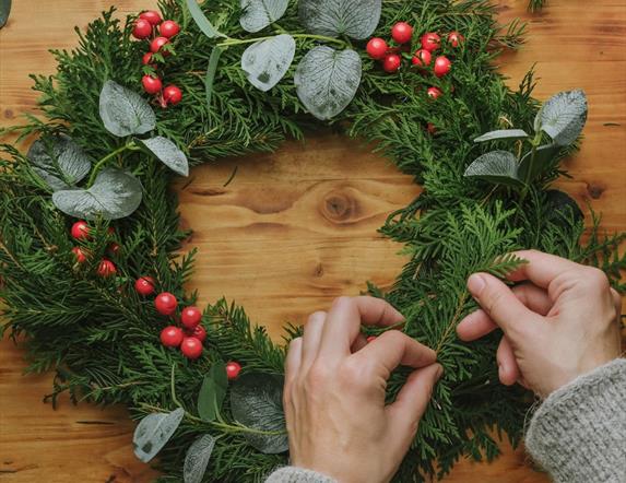 Image is of someone making a Christmas wreath