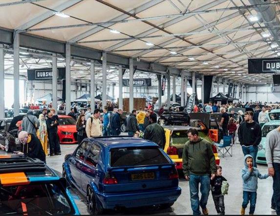 Image is of various cars and visitors at DUBSHED show in the Eikon Exhibition Centre LIsburn