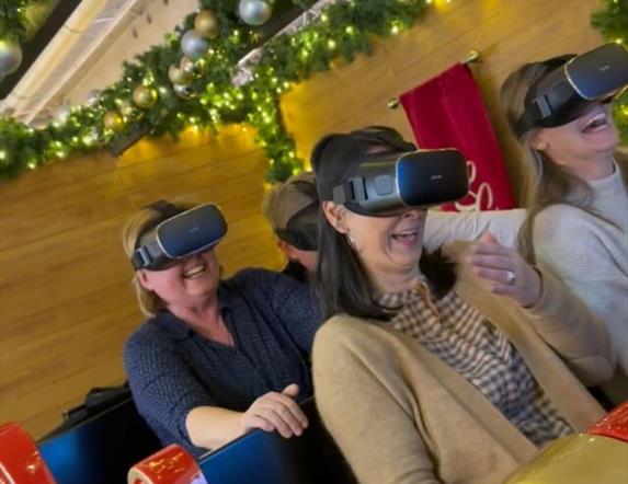 Image is of people taking part in a virtual reality sleigh ride