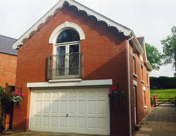 Image shows upstairs apartment patio doors and garage underneath