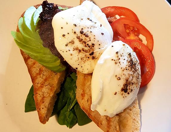 Image shows poached egg on toast with avocado, lettue & tomato.