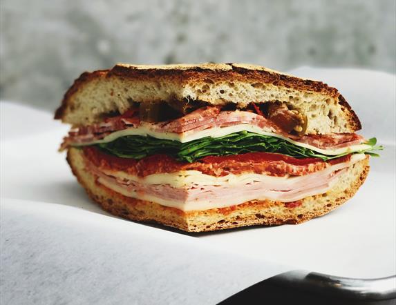 Image shows a sandwich with ham, chicken, bacon lettuce & tomato