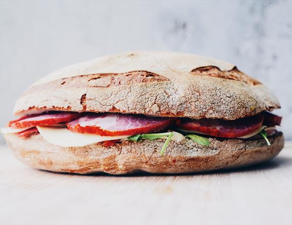 Image shows a ciabatta sandwich with ham and lettuce