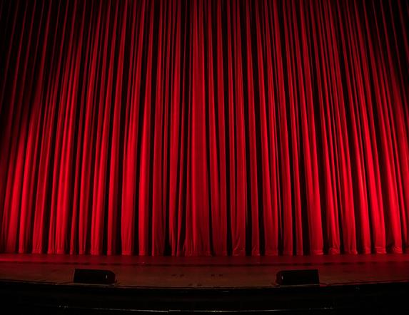 Picture of red curtains on a theatre stage