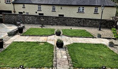 Image shows back of property with landscaped garden area