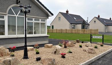 Image shows front of cottages with sign pointing to Reception