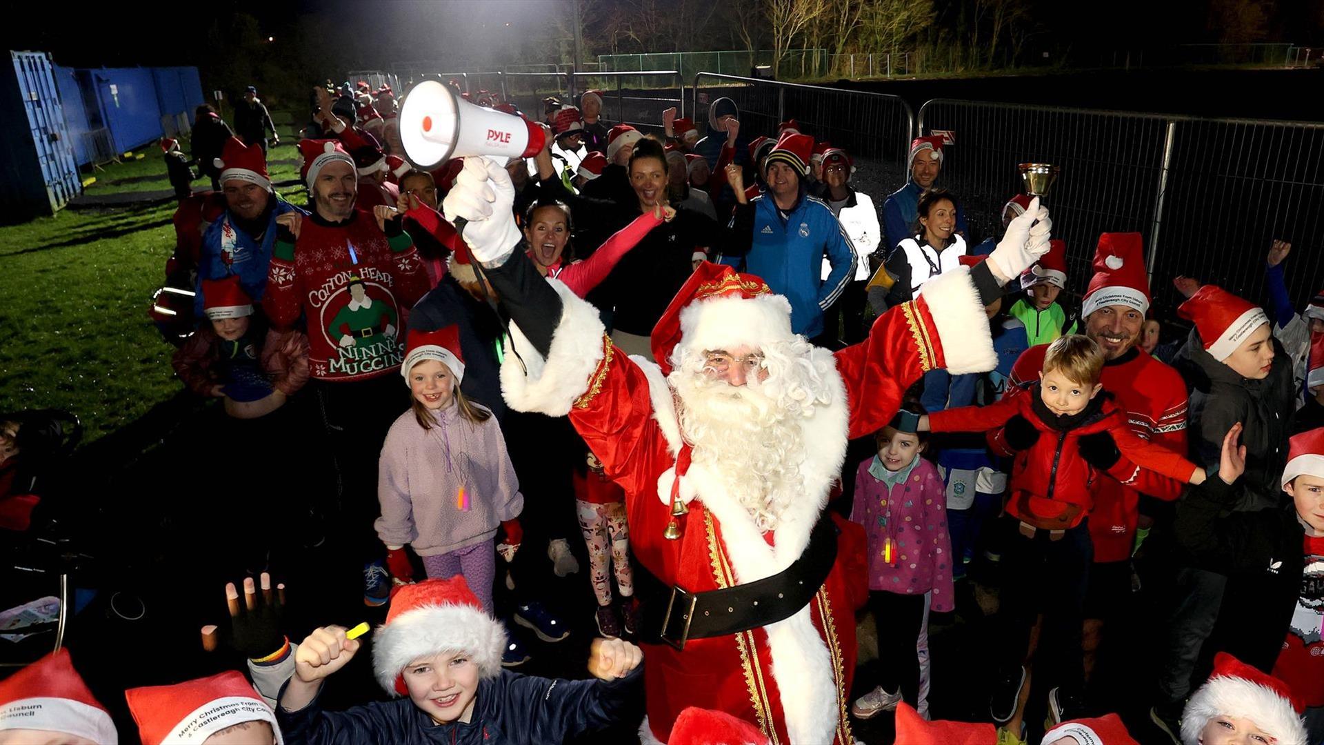 Picture of Santa Clause and surrounding children 
 wearing Santa hats.