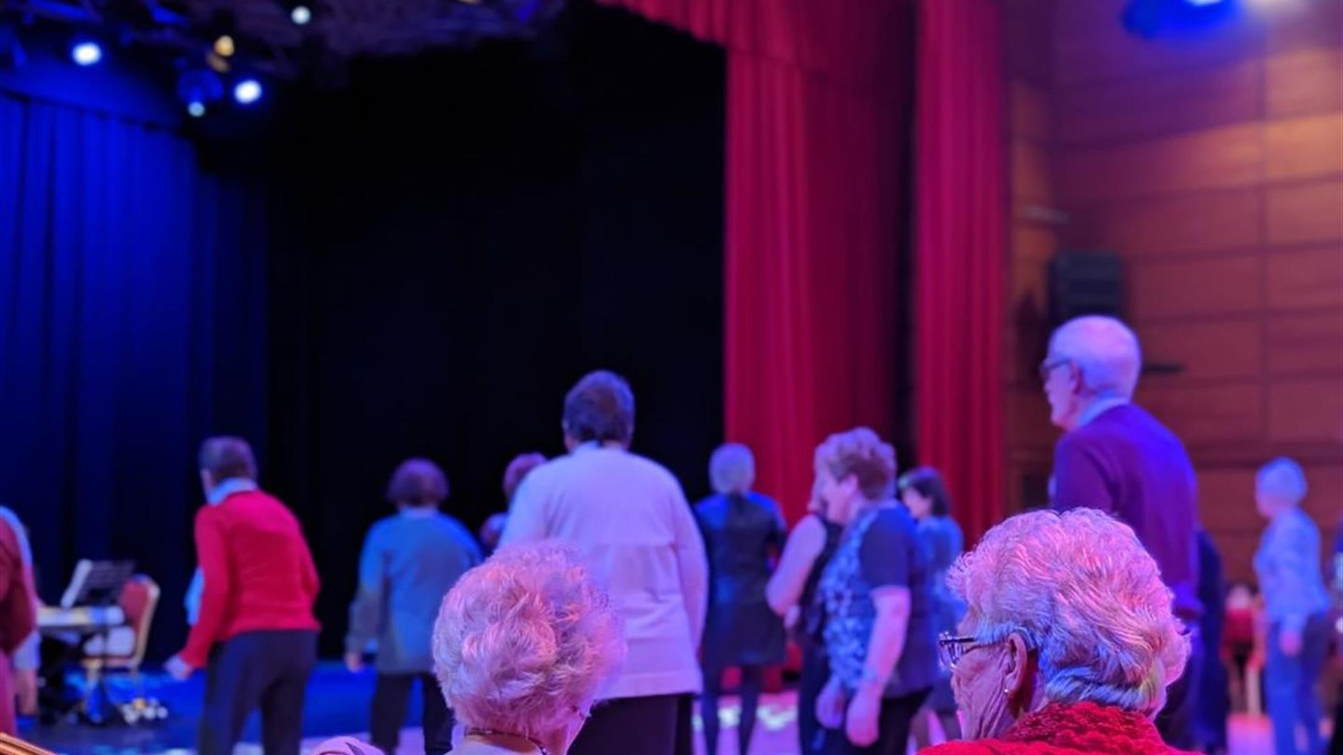 Tea dance participants seated and dancing