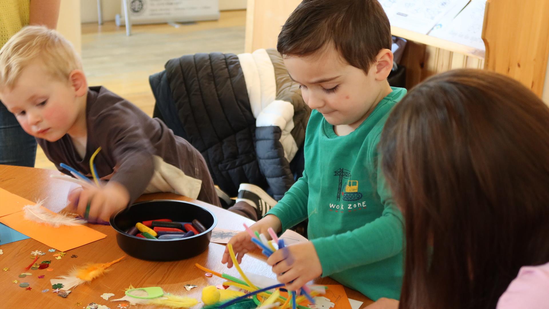 Image is of young children at a craft session in the Irish Linen Centre and Lisburn Museum