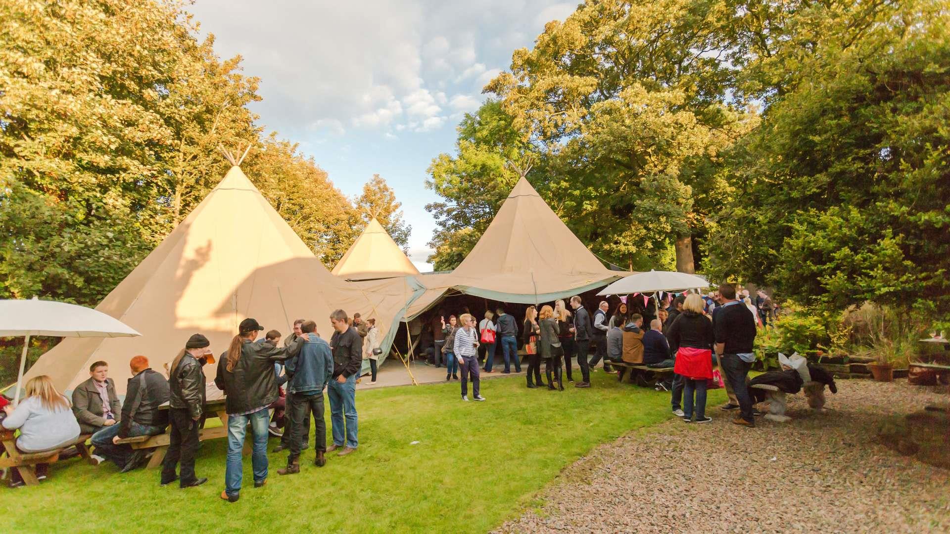 People outside tents on a sunny day at Hilden Beer & Music Festival