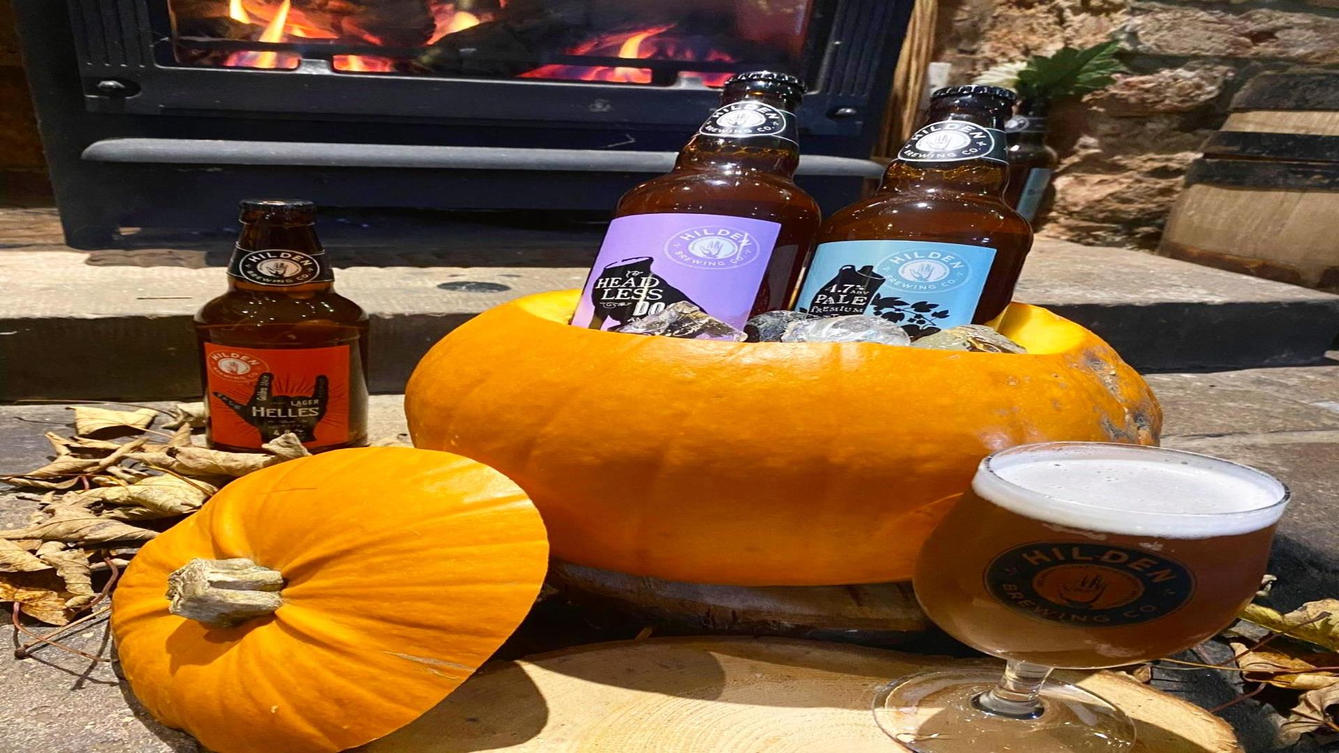 Image is of a pumpkin with beers from Hilden Brewery sitting inside