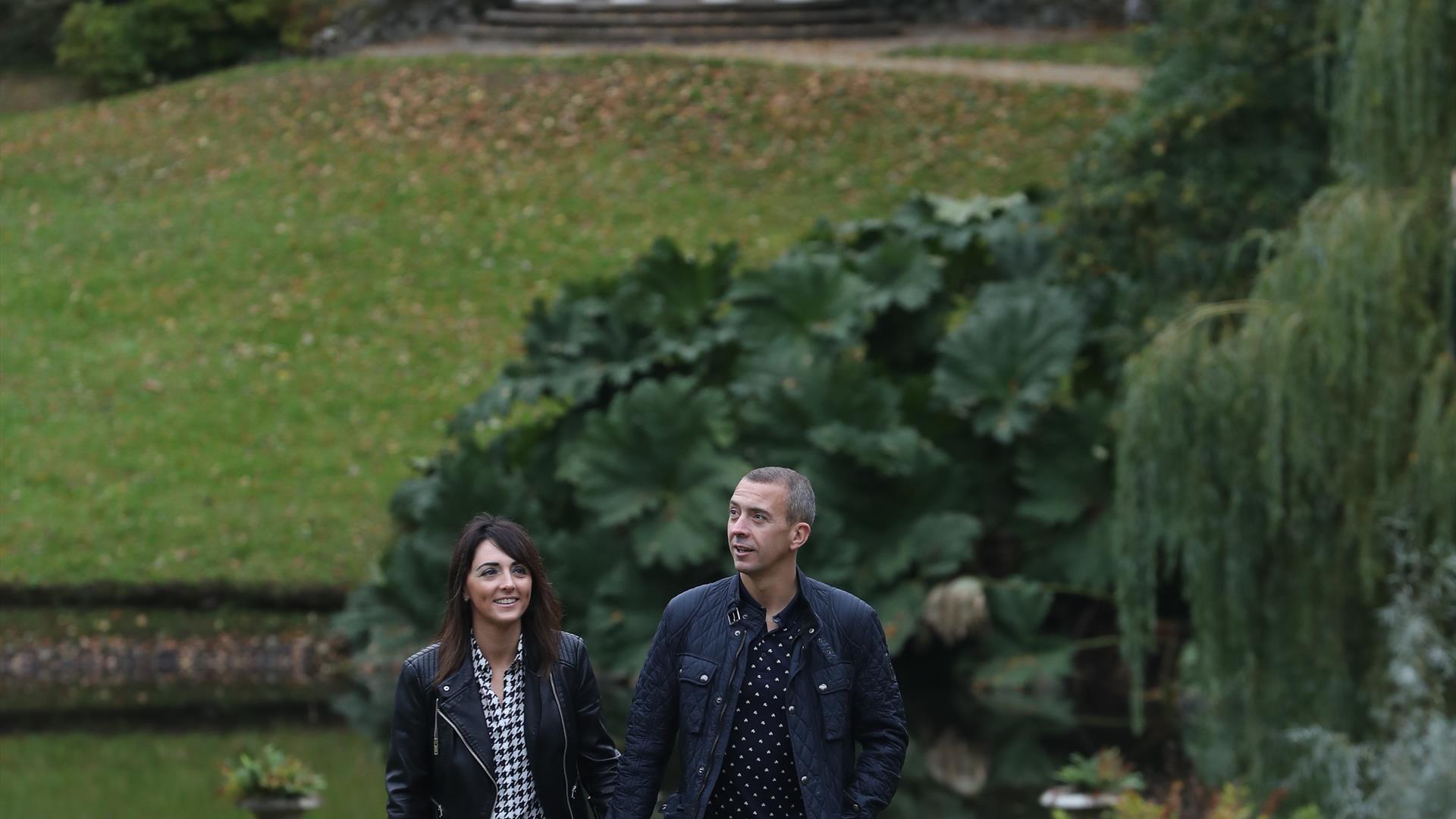 Couple walking in the grounds of Hillsborough Castle with Lady Alice's Temple in the background