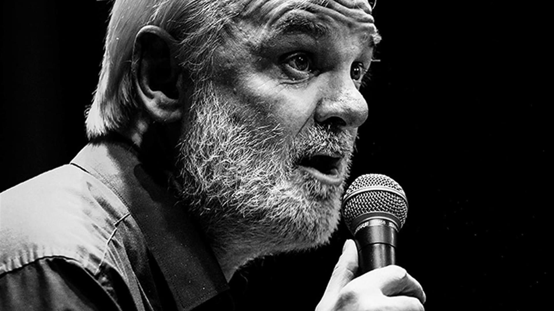 Black and white picture of Tim McGarry with a microphone