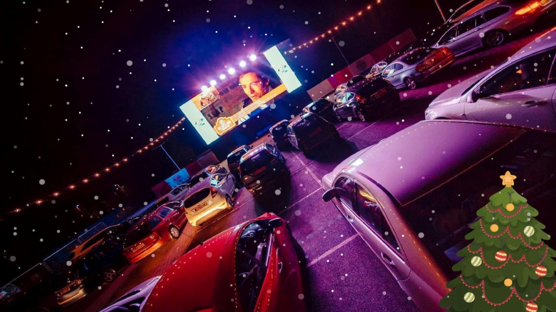 Image shows rows of cars at a drive-in movie