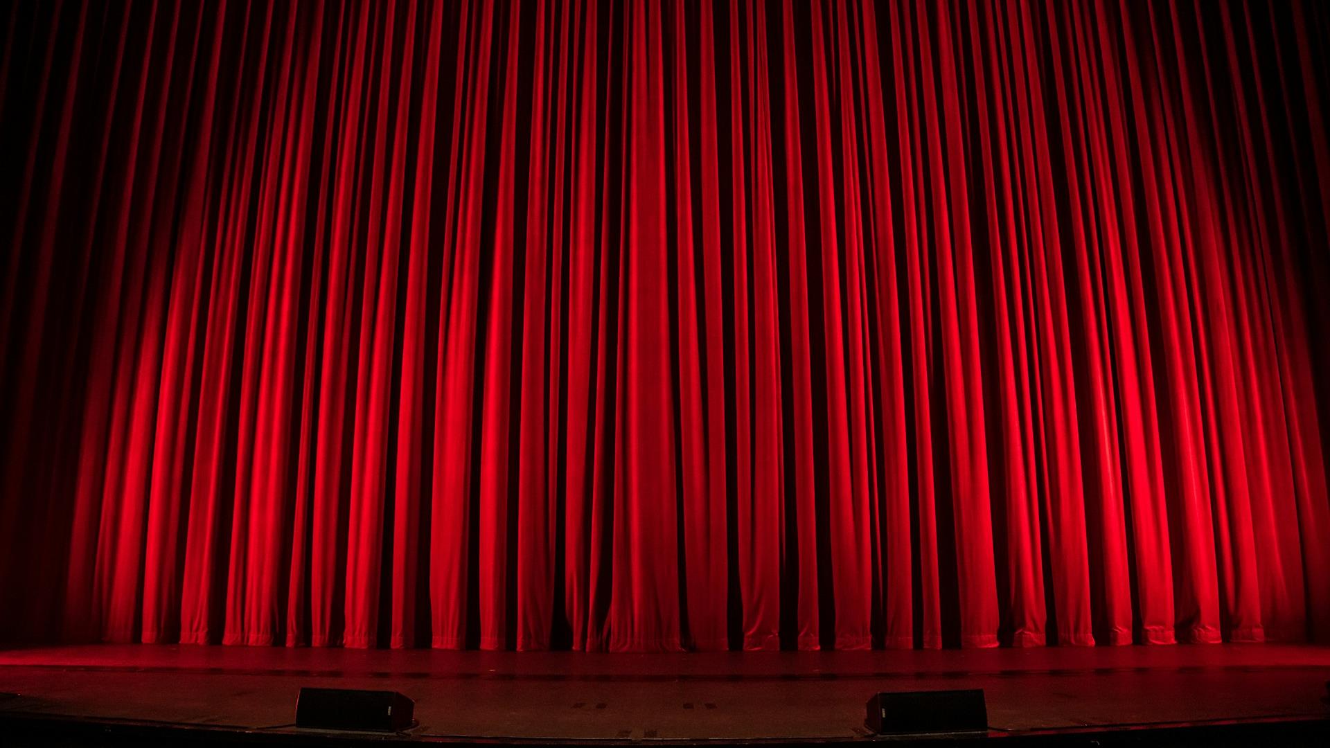 Picture of red curtains on a theatre stage