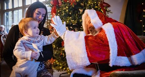 Santa high-fiving child at Santa Brunch at Hillsborough Castle