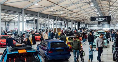 Image is of various cars and visitors at DUBSHED show in the Eikon Exhibition Centre LIsburn