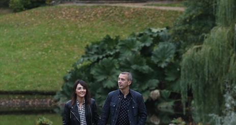 Couple walking in the grounds of Hillsborough Castle with Lady Alice's Temple in the background