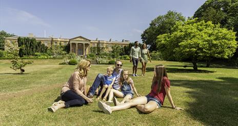 Family sitting on grass in front of Hillsborough Castle