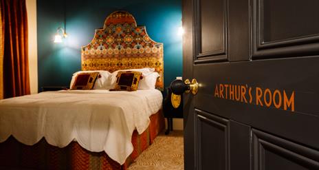 Picture of Arthur's suite inside Arthur's Guesthouse with carefully made double bed and side lamps on the walls