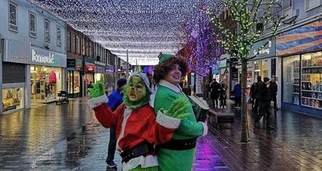 Image is various Christmas characters on a walkabout around Lisburn