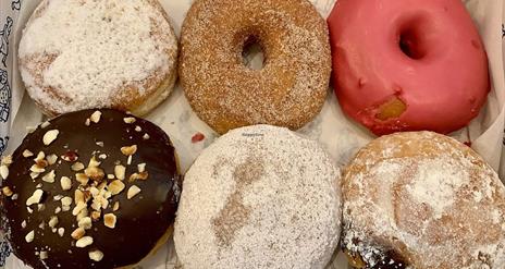 Image shows a box of 6 different donuts