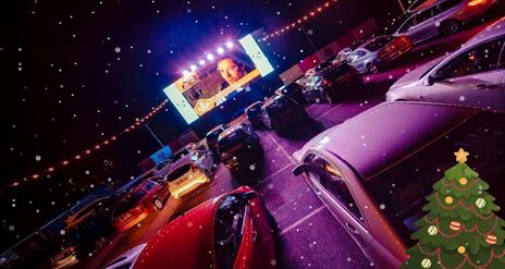 Image shows rows of cars at a drive-in movie