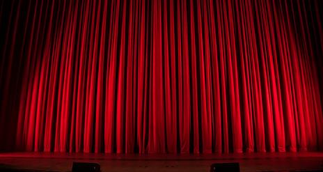 Picture of red curtains on a theatre stage