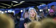 Dundonald Primary School Choir performing at Dundonald Christmas Market in 2023. Picture features a teacher conducting the choir.