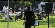 Musician playing at Royal Hillsborough Farmers Market with visitors enjoying the sunshine at Hillsborough Fort