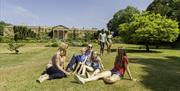 Family sitting on grass in front of Hillsborough Castle