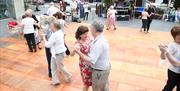 Couples dancing on wooden floor in Market Square, Lisburn