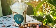 Image shows a milkshake in Cafe Zulu Cup and a chocolate traybake with mini eggs on top