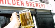 Image shows Hilden Brewery Sign in Red with image of a pint of beer being held.