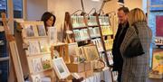 Customers looking at art work at a stall.