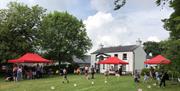 Picture of the Ballance House and activities and people on the lawn