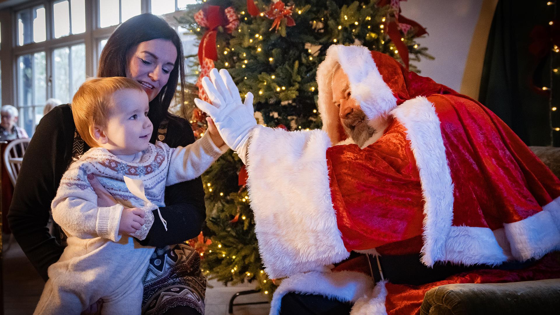 Santa high-fiving child at Santa Brunch at Hillsborough Castle Santa high-fiving child at Santa Brunch at Hillsborough Castle