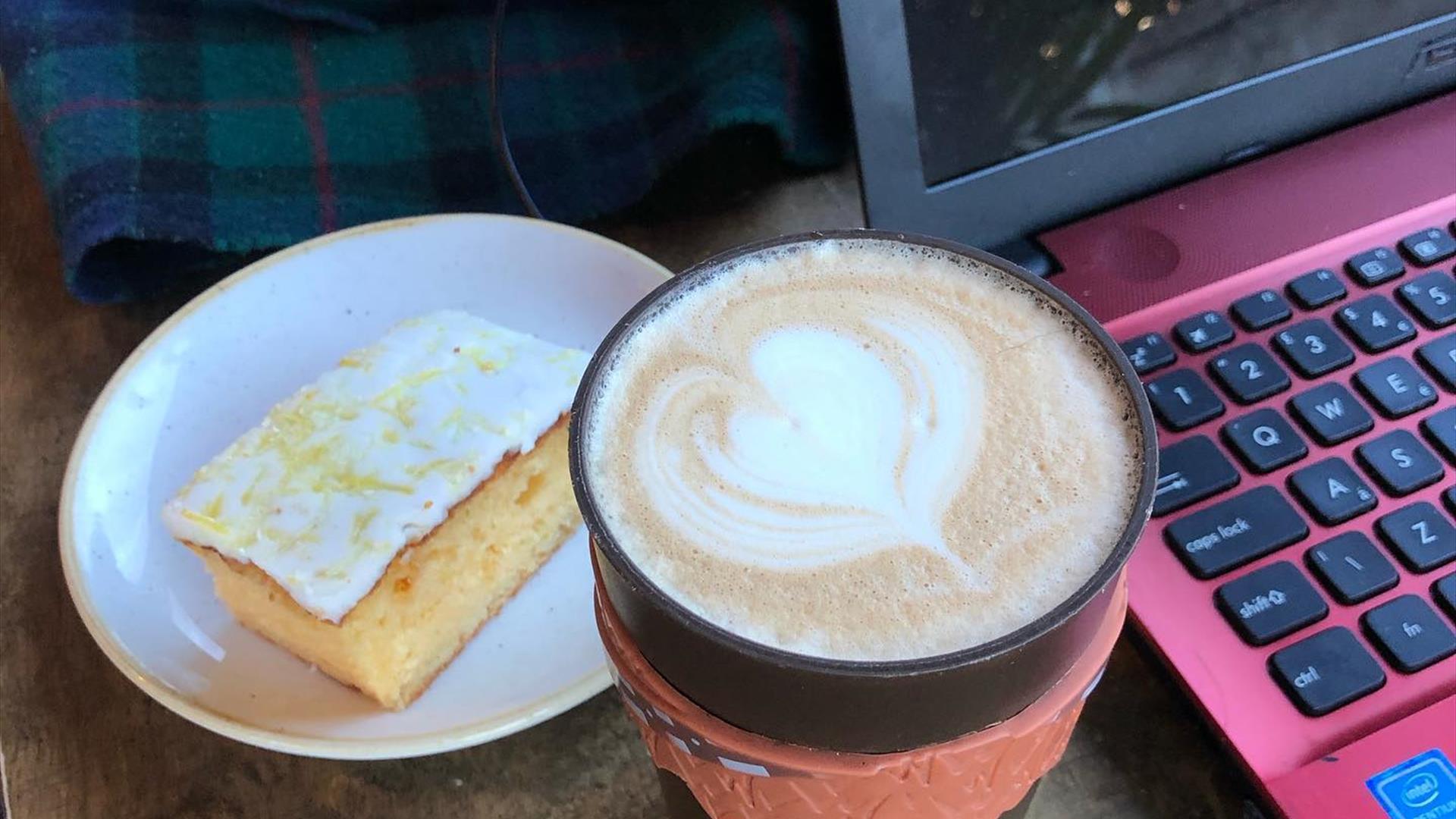 Image is of a cup of coffee and slice of cake in Ground Espresso