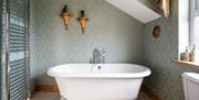 A free standing bath with silver feet and heated towel rail at Drum Manor